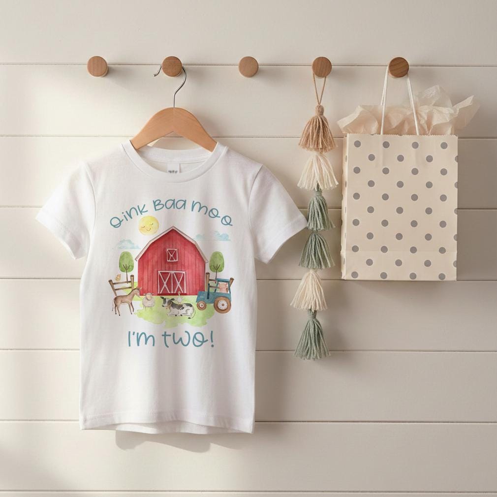 “Oink Baa Moo — I Am Two!" This sweet barn-themed birthday shirt is perfect for your little farmer’s second birthday. Featuring a red barn, watercolor farm animals, and soft neutral tones, it’s the cutest outfit for a barnyard party.  Also makes a great gift!