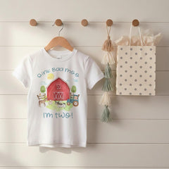 “Oink Baa Moo — I Am Two!" This sweet barn-themed birthday shirt is perfect for your little farmer’s second birthday. Featuring a red barn, watercolor farm animals, and soft neutral tones, it’s the cutest outfit for a barnyard party.  Also makes a great gift!