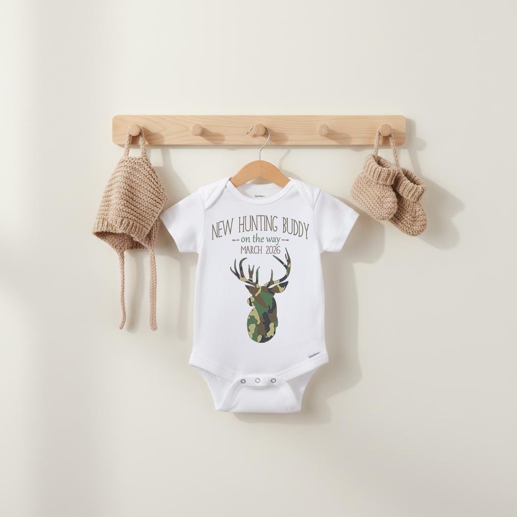 Such a cute pregnancy reveal idea for the hunter in your life!  "New Hunting Buddy on the way" Personalized with your due date.  This hunting/camo theme baby bodysuit or t-shirt is perfect to use as a pregnancy reveal!  Great to send to special family and friends to let them know you are expecting!  Sure to bring lots of smiles!  Also makes a wonderful baby reveal for your social media accounts!  Adorable for big brother or big sister to wear too!!  Perfect for the deer hunting family!
