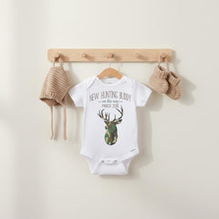 Such a cute pregnancy reveal idea for the hunter in your life!  "New Hunting Buddy on the way" Personalized with your due date.  This hunting/camo theme baby bodysuit or t-shirt is perfect to use as a pregnancy reveal!  Great to send to special family and friends to let them know you are expecting!  Sure to bring lots of smiles!  Also makes a wonderful baby reveal for your social media accounts!  Adorable for big brother or big sister to wear too!!  Perfect for the deer hunting family!