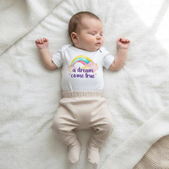 Rainbow baby onesie that says "A Dream Come True" for pregnancy after loss, newborn gift, rainbow baby announcement outfit, neutral baby shower gift, miracle baby outfit, IVF pregnancy reveal, emotional rainbow baby clothing for photography, soft cotton baby bodysuit perfect for maternity photos and welcoming baby after loss.